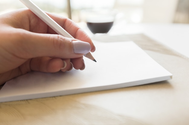 Woman writing in notepad