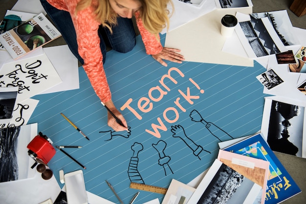 Woman writing Teamwork on a paper