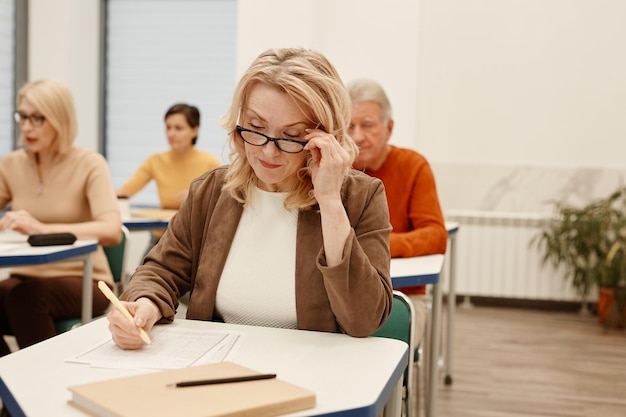 Woman writing test in classroom