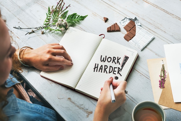 Photo woman writing work harder on a notebook