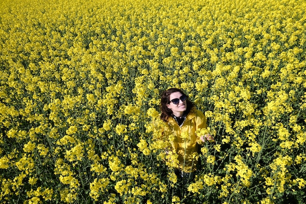 Woman and yellow flowers of rapeseed