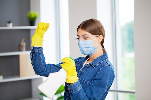 A woman in yellow gloves cleans the office