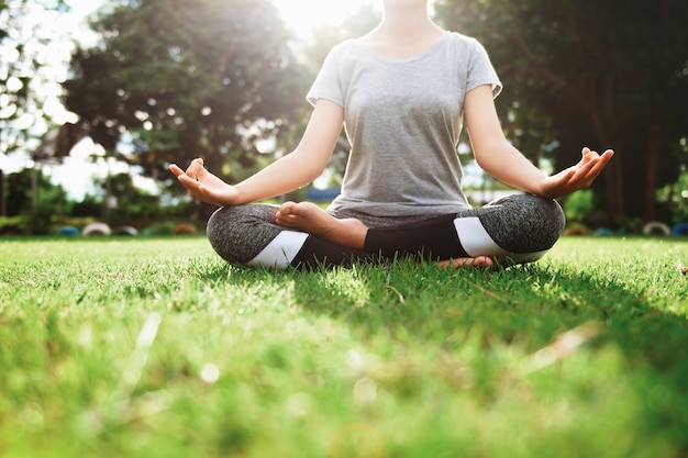 Foto yoga donna e meditare nella posizione del loto al parco in mattinata