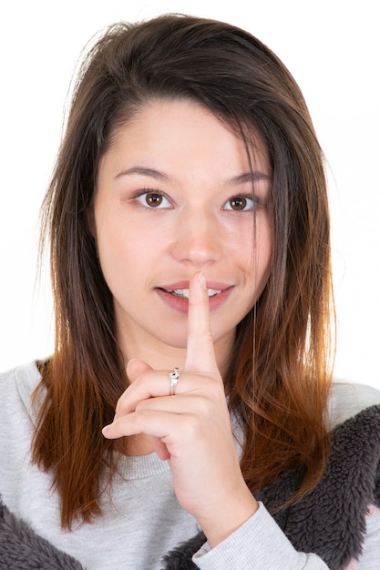 Woman young asking for silence or secrecy with finger on lips shh hand gesture 