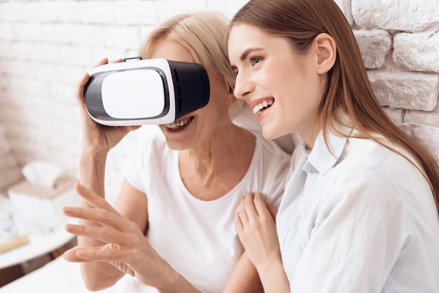 Woman and young girl try on glasses of virtual reality