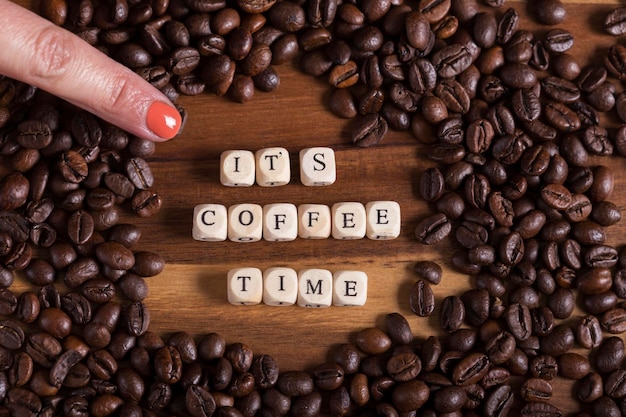 Woman39s finger pointing the phrase its time coffee on wooden cubes