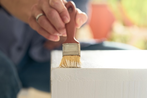 Woman39s hand schilderen van witte houten meubels met een borstel