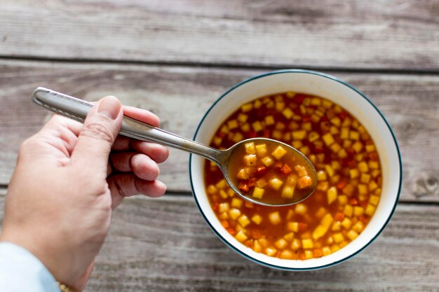 Woman39s hand with spoon in tomato soup