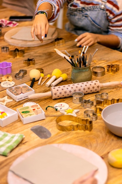 Foto mani di donna che lavorano la ceramica su un tavolo con strumenti