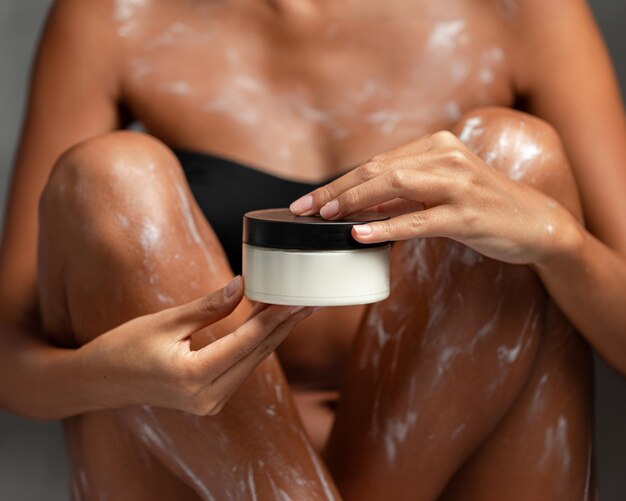 Womans body applied with moisturizing lotion