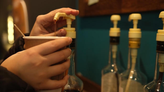 Womans hand adding syrup in ciffee Hazel syrup for coffee Nuts coffee like syrup Coffee with syrup