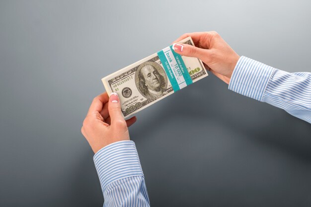 Womans&amp;#39; hand holding dollar bundle. Female employee holds money bundle. So fresh and nice. Not bad for first salary.