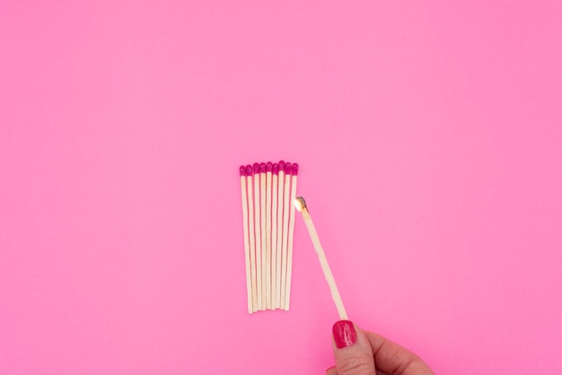 Womans hand holding lit matchstick