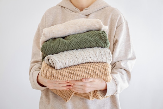 womans hand holding a stack of clothes clothes donation renewable concept washing decluttering