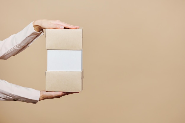 Photo womans hand holds cardboard boxes for delivery food and clothing with home delivery