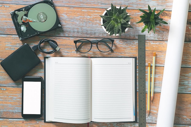 A womans hand holds a pen and writes on a clean sheet of paper White office desk with laptop