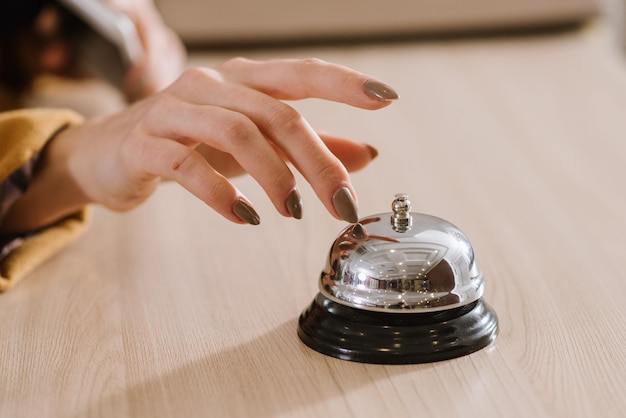 A womans hand on the hotel bell at the reception