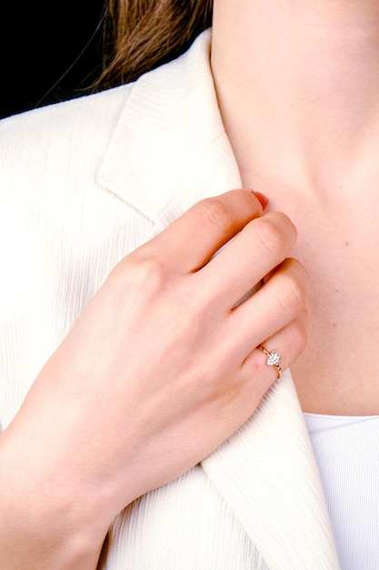 a womans hand is touching the neck of a white jacket