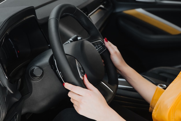 Womans hand on the steering wheel.