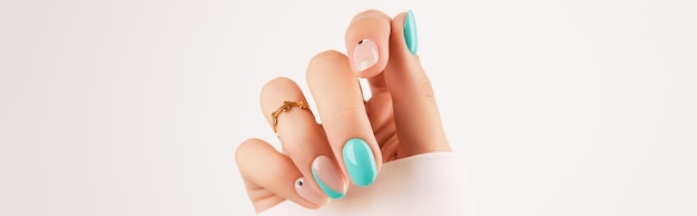 Womans hand with trendy turquoise manicure with copy space