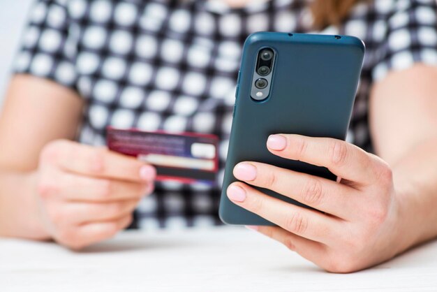 Womans hands hold credit card and use smartphone to shop online online shopping