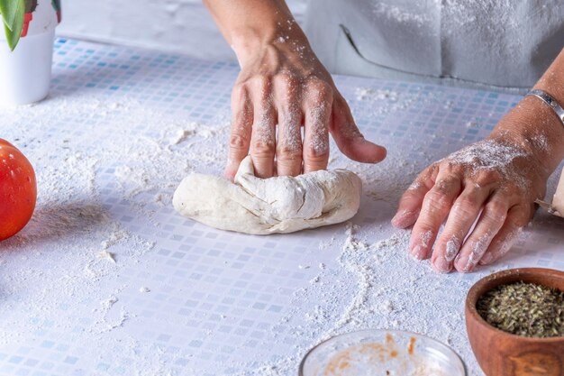 Foto le mani delle donne che impastano un gnocco di farina