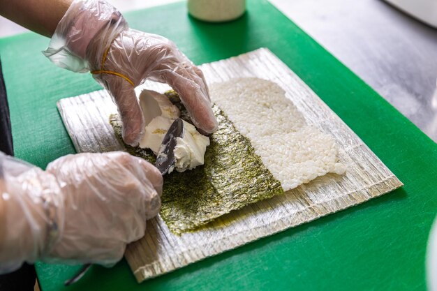 Womans hands making japanese rolls