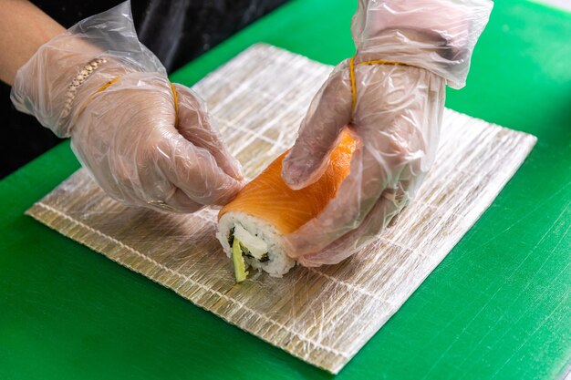 Womans hands making japanese rolls