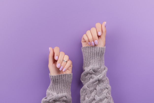 Womans hands with fashionable lavender manicure winter christmas nail design