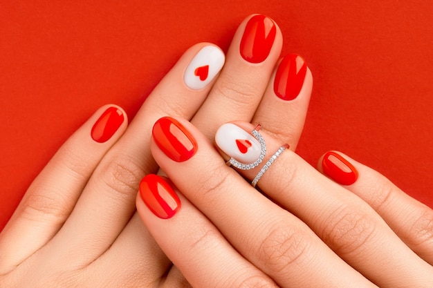 Womans hands with fashionable red manicure valentines day nail design