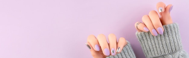 Womans hands with matte lavender and silver nails beauty treatment