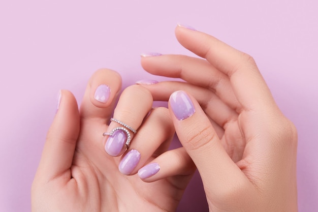 Womans hands with trendy lavender manicure Spring summer nail design