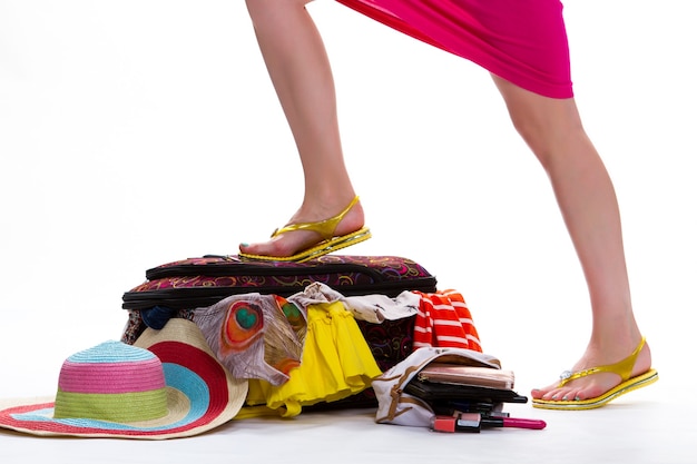 Womans leg on filled suitcase legs in yellow flip flops fashion is everything its not that simple