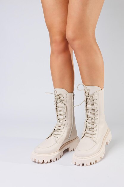 Womans legs in a collection of fashionable leather white shoes on a white background spring collection of womens shoes