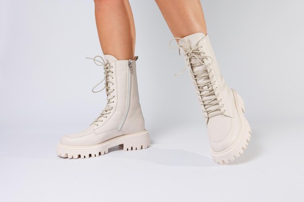 Womans legs in a collection of fashionable leather white shoes on a white background spring collection of womens shoes