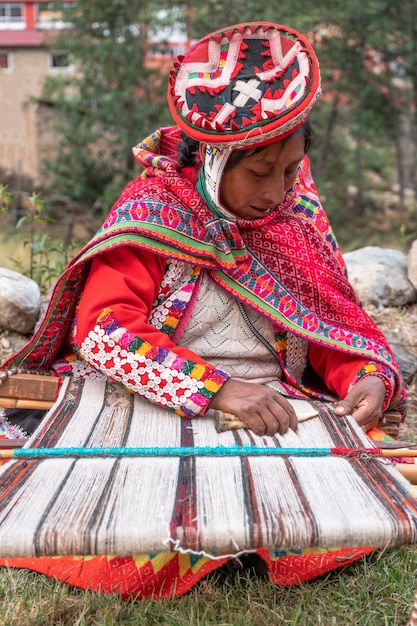 Women in the Andes of Peru weaving with their typical costumes