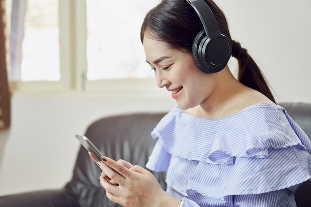 Women are listening to music from black headphones. In a comfortable and good mood.