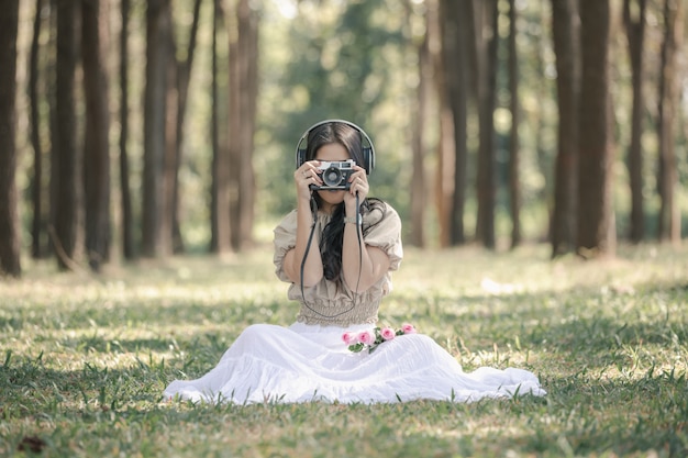 Women are shooting with film camera in the garden  