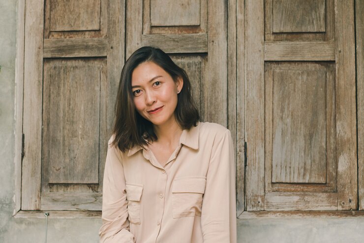 Photo 女性は木製の窓に座っています。