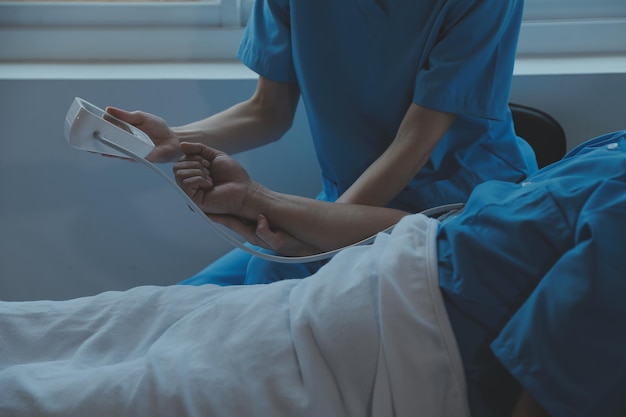 여성 아시아 의사들은 환자의 손을 잡고 격려하고 의학적 조언을 제공하며 침대에서 환자의 건강을 확인하면서 케어 및 연민 산전 관리의 개념 낙태 위협