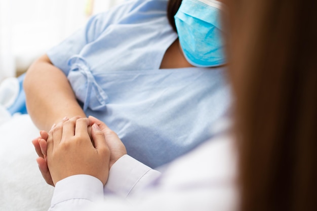 Women Asian doctors hold the patient hand and encourage and provide medical advice