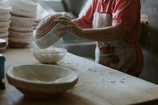 女性がパイを焼く菓子職人がデザートを作るパンをテーブルの上に生地にする