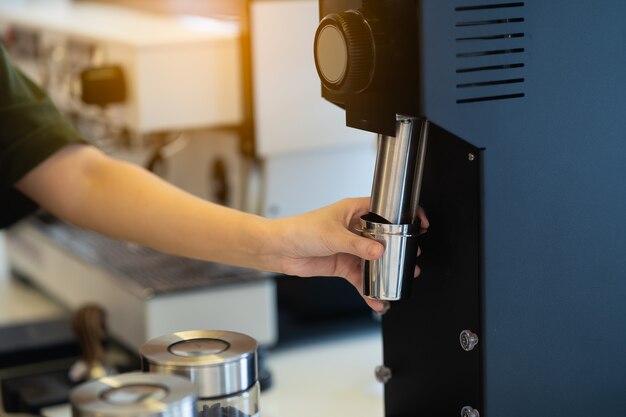 Women barista making coffee in a coffee machine, coffee making concept