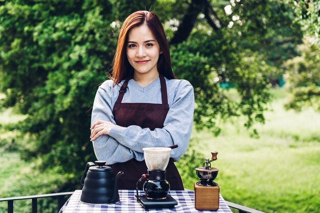 公園でドリップコーヒーを作る女性バリスタ