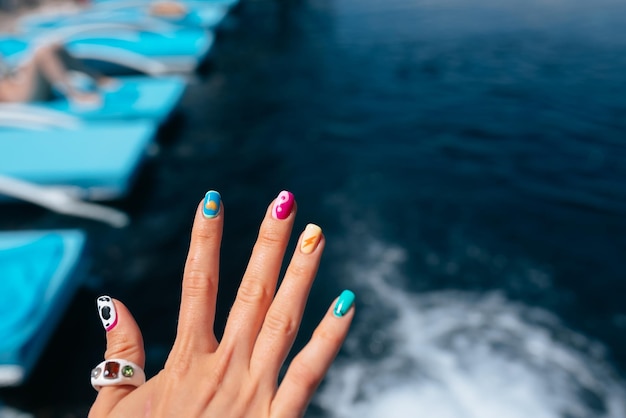 Women beautiful manicure in the pool Close up