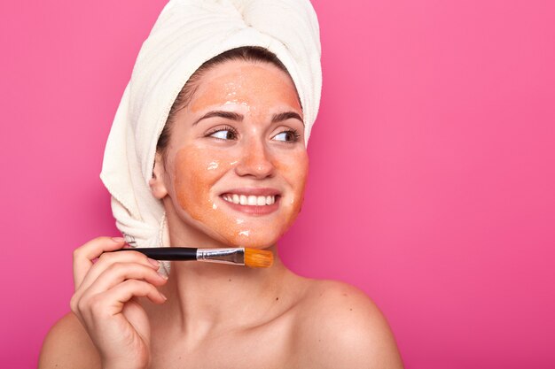 Women and beauty concept. Smiling satisfied European woman wears mask