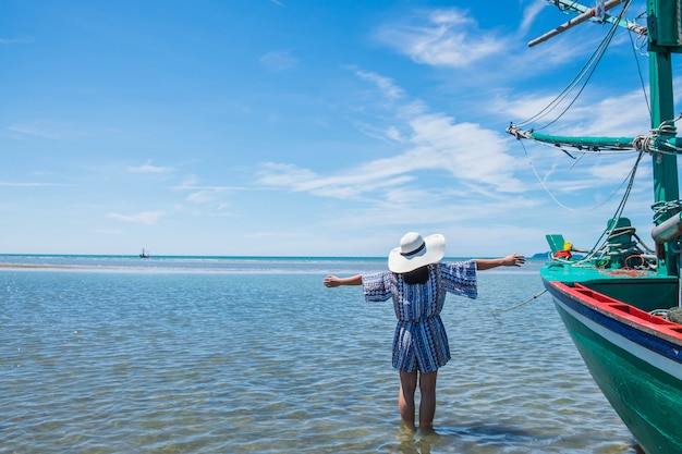 女性と大きな帽子は夏に海へ旅行します。