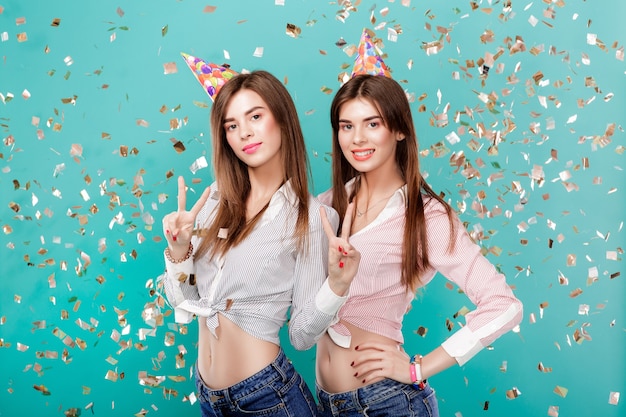 Women in birthday hat and confetti on blue background