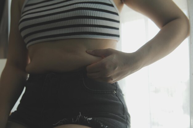 Foto donne pancia grassa del corpo donna obesa mano che tiene eccessivo pancia grasso dieta concetto di stile di vita per ridurre la pancia e formare muscoli dello stomaco sani