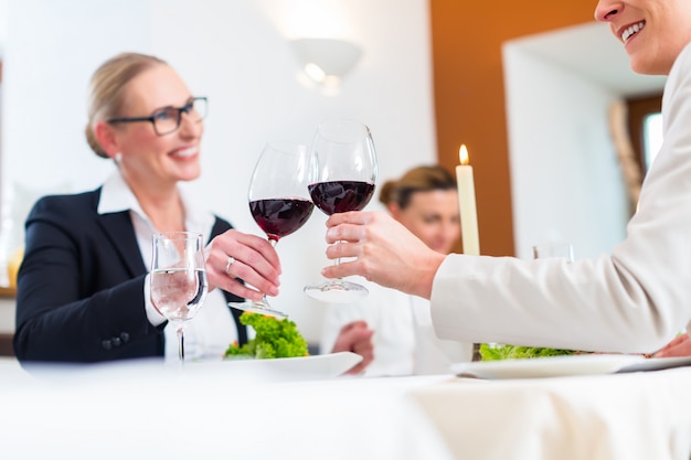 Women on business lunch toasting with wine